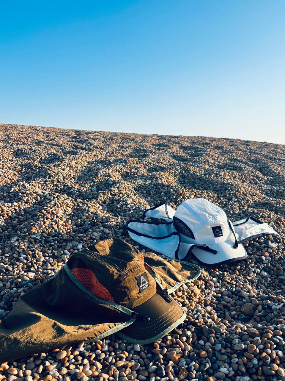 Outsiders Legion Desert Running Cap colourways on outdoor stone